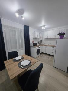 a kitchen with a wooden table and a white refrigerator at Luna Studio in Hunedoara +10 photos