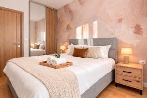 a bedroom with a large bed with a wooden tray on it at Boho Dream Apartments in Ulcinj