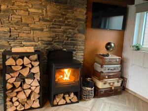 a stone fireplace with a stove and luggage at Travel Wood in Waulsort