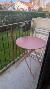 a pink table on a balcony next to a fence at T1 curistes et vacances in Dax