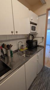 a kitchen with a sink and a microwave at T1 curistes et vacances in Dax