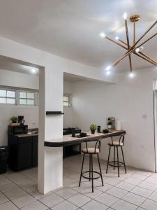 a kitchen with a table and two bar stools at Villa seda in Rincon +18 photos