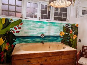 a bathroom with a bath tub with a painting on the wall at Villa seda in Rincon