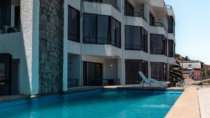 a swimming pool in front of a building at Mahia hotel Reñaca in Viña del Mar