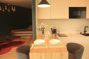 a wooden table with plates and wine glasses on it at Casa dos Americanos - Suite Wellness in Briño