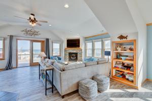 a living room with a couch and a fireplace at 4749 - Salty Dawgs in Kitty Hawk Beach