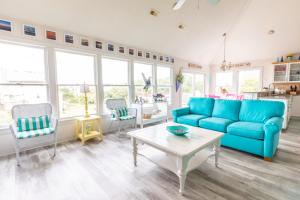 a living room with a blue couch and a table at 4751 - Purple Passion in Kitty Hawk Beach