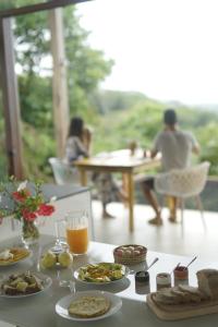 a table with plates of food and people sitting at a table at Fazenda 101 in Ilhéus +22 photos