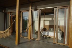 a bedroom with sliding glass doors and a bed at Fazenda 101 in Ilhéus