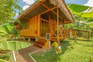 a small wooden house with a straw roof at Hacienda Herrera Tambopata in Puerto Maldonado