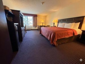 a hotel room with a bed and a window at Inn of Lompoc in Lompoc