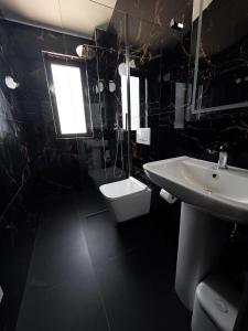 a bathroom with a sink and a toilet at Hotel Margjokaj2 Velipoje in Velipojë