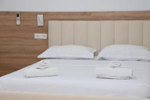 a white bed with two towels on top of it at Hotel Margjokaj2 Velipoje in Velipojë +4 photos