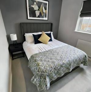 a bedroom with a bed with a comforter and pillows at Your Versatile Luxury - Space for All- Sleeps 10 in Bedford