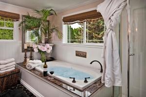 a bathroom with a bath tub with a window at Cozy Rose Inn in Prosser