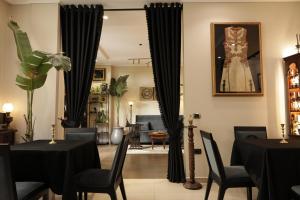 a restaurant with black tables and chairs and a dress in a mirror at Monun Boutique Hotel in Tirana