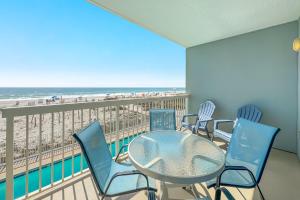 a balcony with a table and chairs and the beach at Caribbean Unit 103 in Gulf Shores