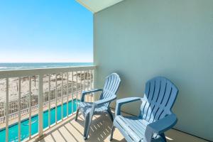 two blue chairs sitting on a balcony with the beach at Caribbean Unit 103 in Gulf Shores