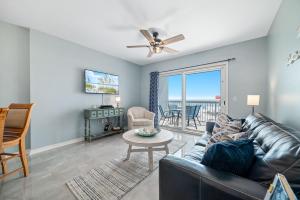 a living room with a leather couch and a tv at Caribbean Unit 103 in Gulf Shores