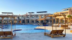 a resort with a swimming pool with chairs and umbrellas at vip ghazala in Dahab