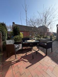 a patio with a table and chairs on a brick patio at Petkumer Deichkoje in Emden