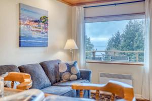 ein Wohnzimmer mit Sofa und großem Fenster in der Unterkunft Sitka Sky in Oceanside