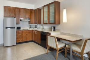 a kitchen with wooden cabinets and a table with chairs at Residence Inn by Marriott Orlando Downtown in Orlando