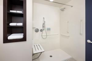 a white bathroom with a shower and a sink at Residence Inn by Marriott Orlando Downtown in Orlando