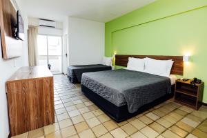 a hotel room with a bed and a desk at El Aram Beach Express in Maceió