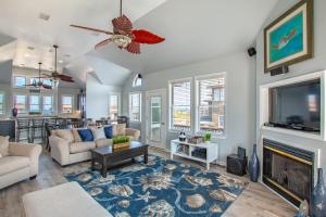 a living room with a fireplace and a tv at 5469 - Below Deck OBX in Nags Head