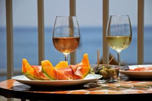 a table with a plate of fruit and two glasses of wine at La maison du sud d'awaji - Ocean View Private Villa in Minamiawaji +22 photos