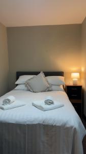 a large white bed with two towels on it at The Turf Hotel in Richmond