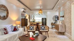 a living room with a white couch and a table at Stanza Mare Beach Front in Punta Cana +263 photos