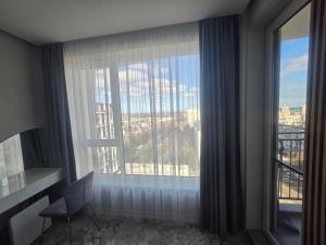 a room with a large window with a view of a city at arena sunrise in Burgas
