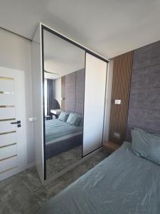 a large mirror in a bedroom with a bed at arena sunrise in Burgas