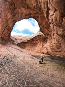 a man standing in front of an arch in a canyon at Kamaq Hostel in Humahuaca