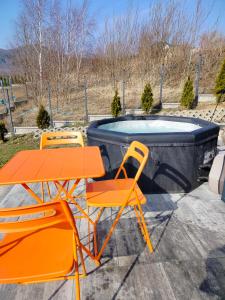 two orange chairs and a table and a pool at Domek Pośród Gór - JACUZZI WLICZONE W CENIE POBYTU,bajeczne widoki, relax i spokój in Laski