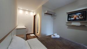 a bedroom with a bed and a tv on the wall at Riviera Sanary 1208 Nova Almeida in Serra