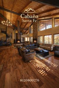 a large living room with leather couches and a fireplace at Cabaña Santa Fe in Mesa de las Tablas