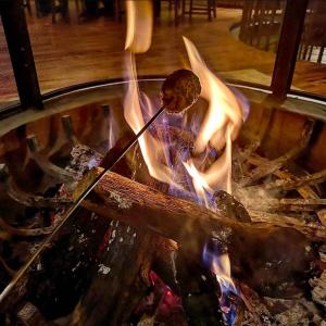a person is cooking food over a fire at Cabaña Santa Fe in Mesa de las Tablas