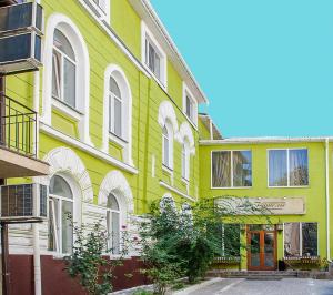 un edificio amarillo y verde con una calle en Guest House De Rishelye, en Odessa