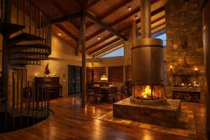a large living room with a fireplace in the middle at Cabaña Santa Fe in Mesa de las Tablas