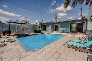 a swimming pool with chairs and a house at Phindulo Bed and Breakfast - No Loadshedding, Smart TVs & unlimited free fibre wifi in Krugersdorp