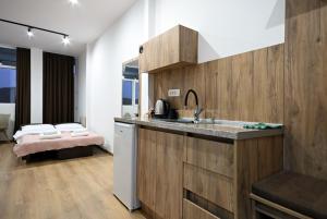 a kitchen with a sink and a bed in a room at Tashev Apartments in Veles