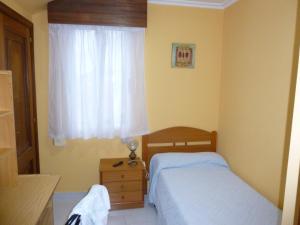 a small bedroom with two beds and a window at Hostal O Choyo II in Ferrol