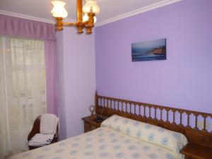 a bedroom with purple walls and a bed and a window at Hostal O Choyo II in Ferrol