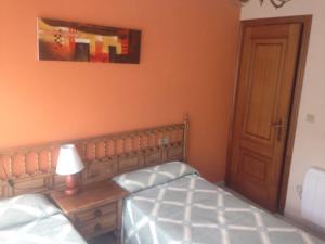 a bedroom with a bed and a table with a lamp at Hostal O Choyo II in Ferrol