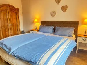 a bedroom with a large bed with blue sheets at Chiemsee Beachhouse Apartment in Bernau am Chiemsee