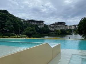 a large swimming pool with buildings in the background at Maison Brise Condominium Unit Pico De Loro Nasugbu in Nasugbu