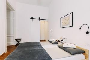 a white room with two pillows on a couch at L'Arco Trieste studio living 1 in Trieste